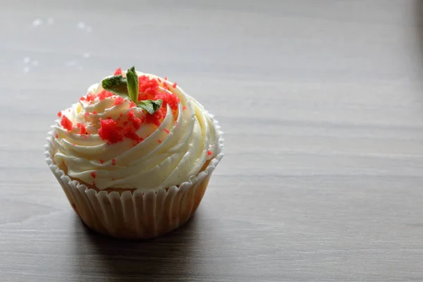 Cupcake en velours rouge. Les gâteaux finis sont sur la table. Décoré avec des feuilles de menthe . — Photo