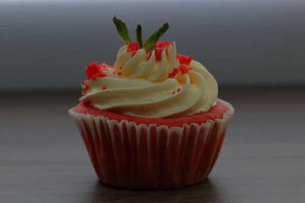 Cupcake en velours rouge. Les gâteaux finis sont sur la table. Décoré avec des feuilles de menthe . — Photo