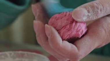 Bir kadın bir fırça kullanarak marshmallow için şeker tozu uygular. Bir kenara koyuyor. Close.