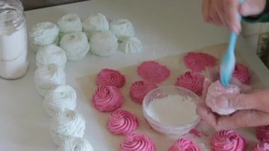 Bir kadın kızılcık şekerlemelerine pudra şekeri koyar. Yukarıdan görüntüle.