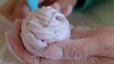 Bir kadın bir pasta fırçası kullanarak pudra şekeri ile marshmallow davranır. Close.