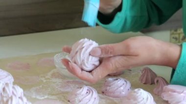 Bir kadın bir pasta fırçası kullanarak pudra şekeri ile marshmallow davranır.