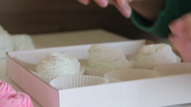 Kadın ev yapımı şekerlemeleri hediye kutusuna koyar. Yakın plan..