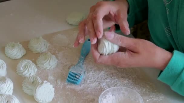 食品用紙には 粉砂糖を散布したマシュマロが乾燥します 女性は粉砂糖に抱きしめる 上からの眺め — ストック動画