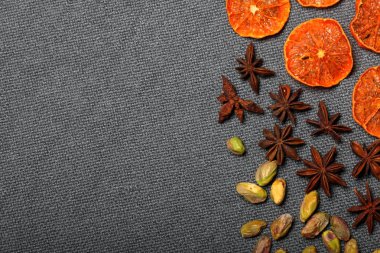 Kurutulmuş mandalina tatlı süslemek için parçalara ayrılır. Otelin yakınında antep fıstığı ve anason bulunmaktadır. Gri arka planda.