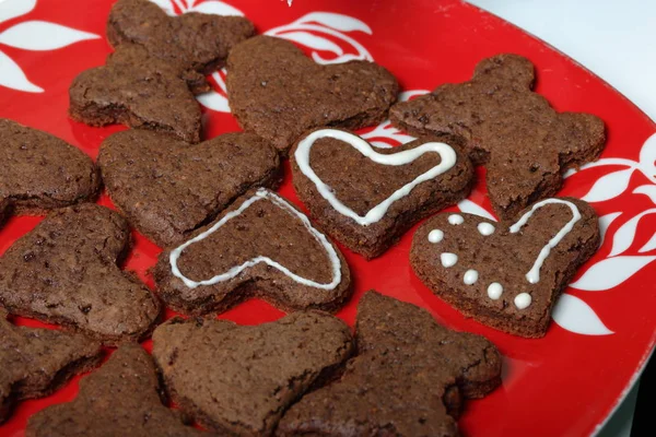 Galletas de jengibre al horno están acostados en un plato. Algunas están decoradas con glaseado blanco. Cocinar pan de jengibre . — Foto de Stock