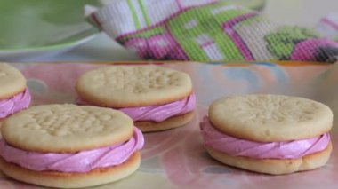 Pişmiş marshmallowlu sandviç. Yemek kağıdına yatarlar. Kadın durumu düzeltir.