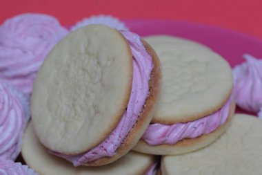 Pişmiş marshmallowlu sandviç. Tabakta yatıyorlar. Tabakta bir sonraki çeşitli boyutlarda bir marshmallow olduğunu.