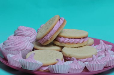 Pişmiş marshmallowlu sandviç. Tabakta yatıyorlar. Tabakta bir sonraki çeşitli boyutlarda bir marshmallow olduğunu.