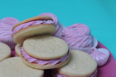 Pişmiş marshmallowlu sandviç. Tabakta yatıyorlar. Tabakta bir sonraki çeşitli boyutlarda bir marshmallow olduğunu.