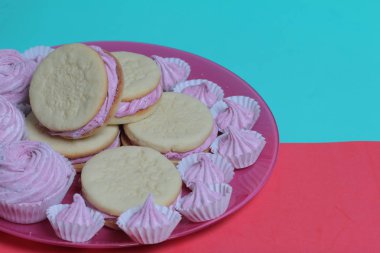 Pişmiş marshmallowlu sandviç. Tabakta yatıyorlar. Tabakta bir sonraki çeşitli boyutlarda bir marshmallow olduğunu.