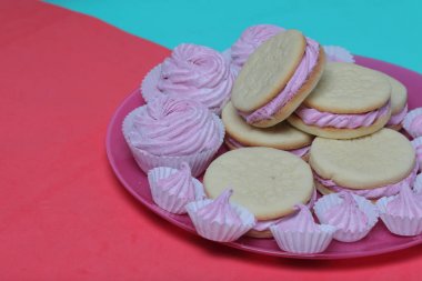Pişmiş marshmallowlu sandviç. Tabakta yatıyorlar. Tabakta bir sonraki çeşitli boyutlarda bir marshmallow olduğunu.
