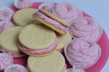 Pişmiş marshmallowlu sandviç. Tabakta yatıyorlar. Tabakta bir sonraki çeşitli boyutlarda bir marshmallow olduğunu.