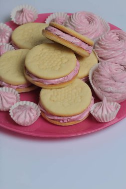 Pişmiş marshmallowlu sandviç. Tabakta yatıyorlar. Tabakta bir sonraki çeşitli boyutlarda bir marshmallow olduğunu.