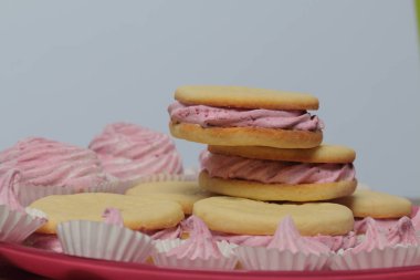 Pişmiş marshmallowlu sandviç. Tabakta yatıyorlar. Tabakta bir sonraki çeşitli boyutlarda bir marshmallow olduğunu.