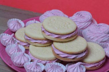 Pişmiş marshmallowlu sandviç. Tabakta yatıyorlar. Tabakta bir sonraki çeşitli boyutlarda bir marshmallow olduğunu.