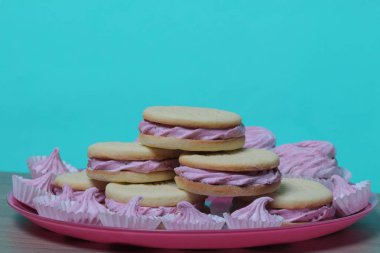 Pişmiş marshmallowlu sandviç. Tabakta yatıyorlar. Tabakta bir sonraki çeşitli boyutlarda bir marshmallow olduğunu.