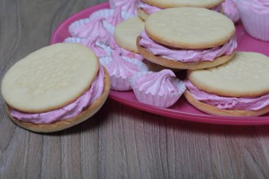 Pişmiş marshmallowlu sandviç. Tabakta yatıyorlar. Tabakta bir sonraki çeşitli boyutlarda bir marshmallow olduğunu.