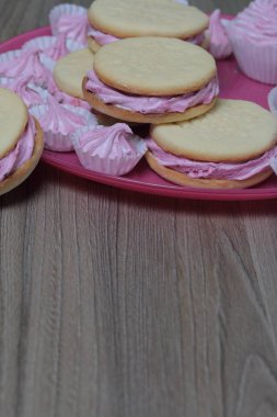 Pişmiş marshmallowlu sandviç. Tabakta yatıyorlar. Tabakta bir sonraki çeşitli boyutlarda bir marshmallow olduğunu.