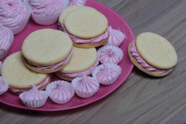 Pişmiş marshmallowlu sandviç. Tabakta yatıyorlar. Tabakta bir sonraki çeşitli boyutlarda bir marshmallow olduğunu.