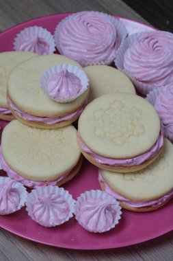 Pişmiş marshmallowlu sandviç. Tabakta yatıyorlar. Tabakta bir sonraki çeşitli boyutlarda bir marshmallow olduğunu.