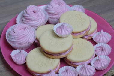 Pişmiş marshmallowlu sandviç. Tabakta yatıyorlar. Tabakta bir sonraki çeşitli boyutlarda bir marshmallow olduğunu.