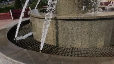 Meşgul bir şehir caddesinde çeşme çalışıyor. Ağır çekim. Yakın plan..