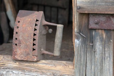 Kömürler üzerinde çalışan nadir demir. Eski bir ahşap barakanın eşiğinde duruyor..