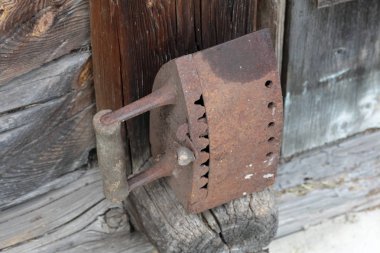 Kömürler üzerinde çalışan nadir demir. Eski ahşap bir ahırın kirişinin üzerinde duruyor..