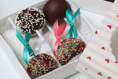 Pasta bir hediye kutusuna paketlenmiş, örgü bir yay ile süslenmiş açılır.