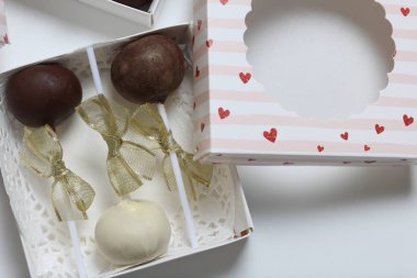 Pasta bir hediye kutusuna paketlenmiş, örgü bir yay ile süslenmiş açılır.