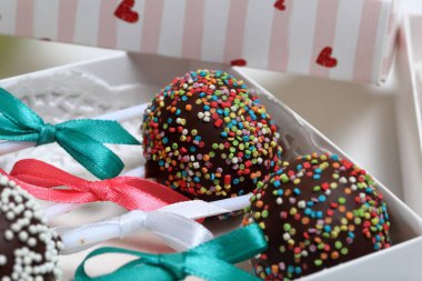 Pasta bir hediye kutusuna paketlenmiş, örgü bir yay ile süslenmiş açılır.