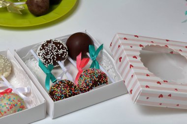 Pasta bir hediye kutusuna paketlenmiş, örgü bir yay ile süslenmiş açılır.