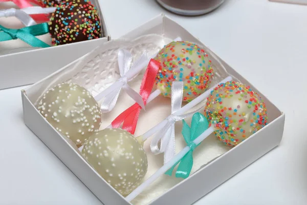 Pastel pops decorado con un lazo de trenza, embalado en una caja de regalo . — Foto de Stock