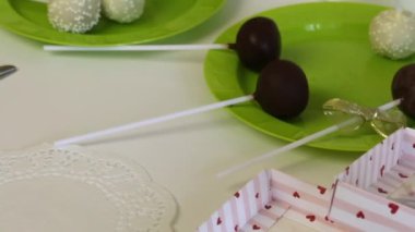 Ev yapımı kek pops ambalaj önce tabaklarda yalan. Şeker siyah beyaz çikolata ile kaplı. Çeşitli tepesi ile. Yakınlarda paketleme için hediye kutuları bulunmaktadır.