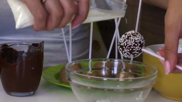 Bir Kadın Beyaz Bir Sos Içinde Koyu Çikolata Ile Popcake — Stok video