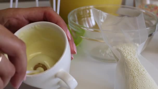 女人把蛋糕泡在白巧克力里 桌子上的下一个是一个白色的爆米花 — 图库视频影像