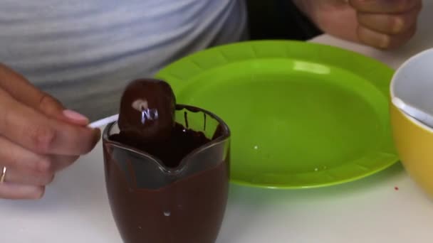 女人在黑巧克力里蘸蛋糕 桌子上的下一个是工具 — 图库视频影像