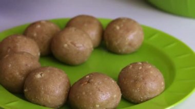 Bir kadın elinde yoğunlaştırılmış süt ile bisküvi topları rulo. Hazır toplar bir tabağa koyar.