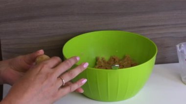 Bir kadın elinde yoğunlaştırılmış süt ile bisküvi topları rulo. Kek pops için pişirme temelleri.