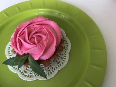 Pasta sepeti. Krem peynir gül ve nane yaprakları ile dekore edilmiştir. Dikdörtgen beyaz bir tabağa yığılmış. Yukarıdan görüntüle.