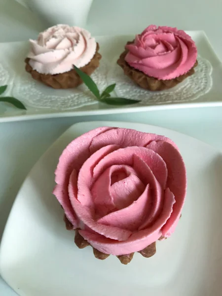 Keranjang kue. Dihiasi dengan krim keju mawar dan daun mint. Ditumpuk di piring putih persegi panjang. Lihat dari atas . — Stok Foto