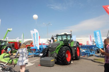 Minsk, Minsk, Belarus 6 Haziran 2019, sergi BelAgro 2019 yılında fuar. Tekerlekli sandalyede bir çocuk olan bir anne sergiler bakıyor.