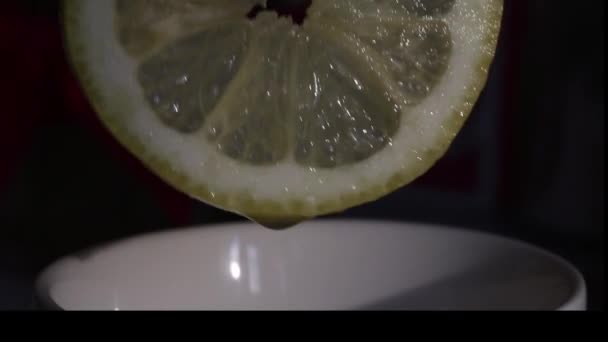 一个男人把柠檬汁挤进杯子里 柠檬是新鲜多汁的 它可以被看作是果汁滴进杯子 拍摄特写 — 图库视频影像