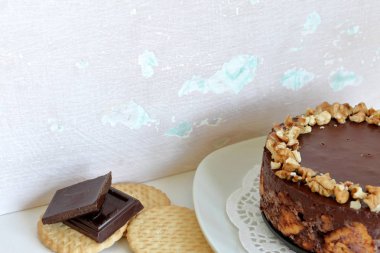 Kurabiye ve çikolata pişirmeden kek. Ceviz kırıntıları ile dekore edilmiştir. Eski miş yaşlı bir arka planda.