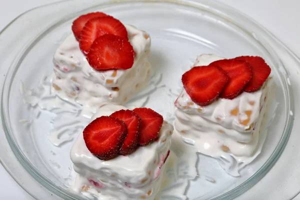Gâteaux de biscuits, crème sure et fraises. Décoré avec des tranches de fraise. Allongé sur une assiette . — Photo