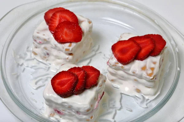 Pasteles de galletas, crema agria y fresas. Decorado con rodajas de fresa. Acuéstese en un plato . —  Fotos de Stock