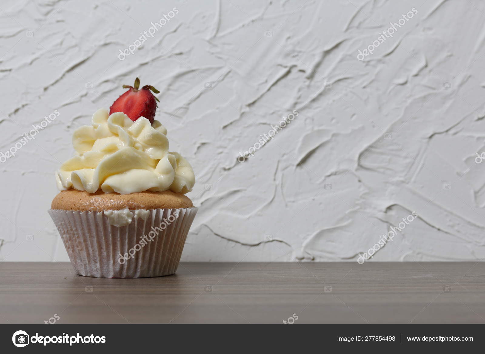 Cupcakes With Strawberries And Butter Cream Against The