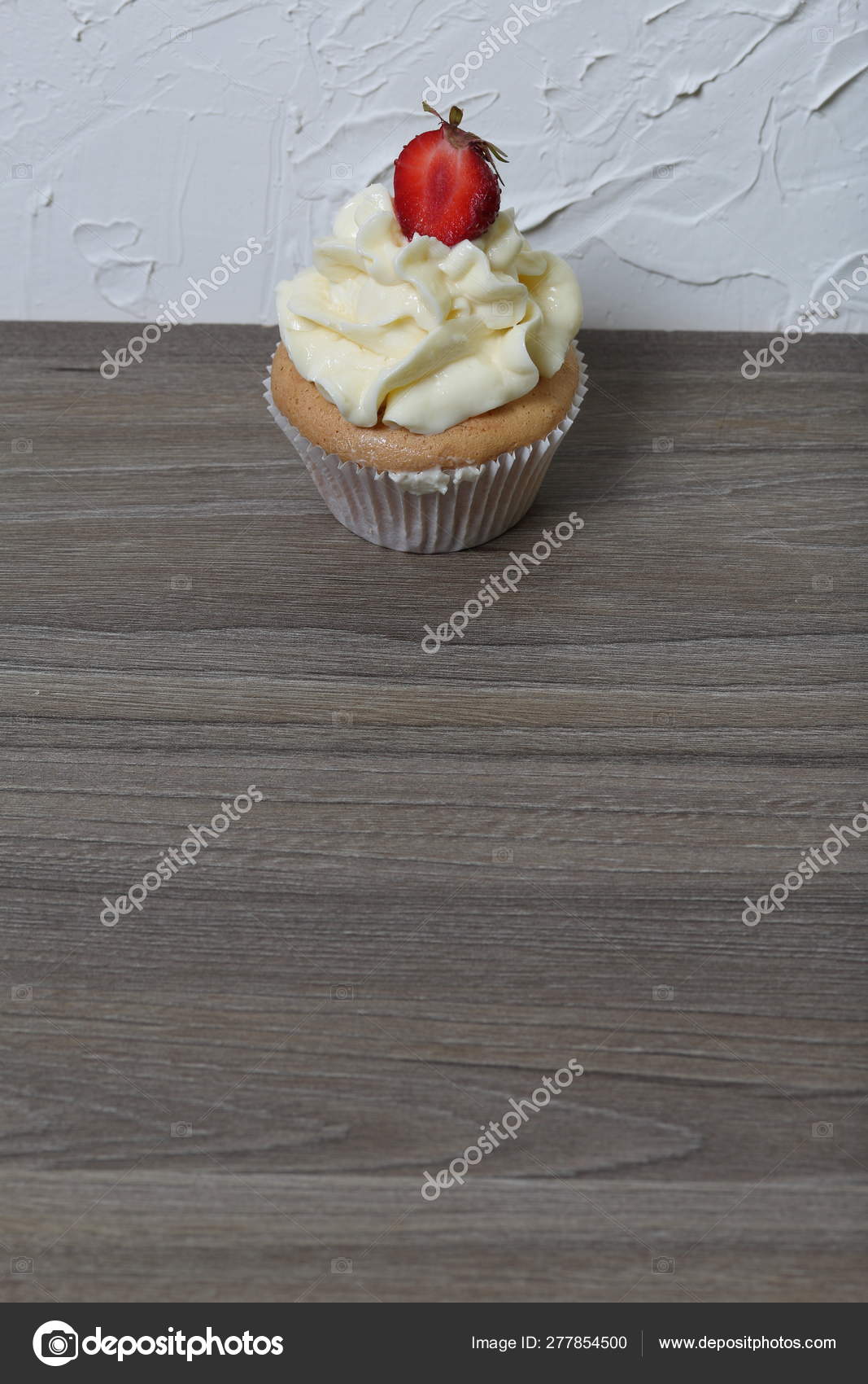 Cupcakes With Strawberries And Butter Cream Against The