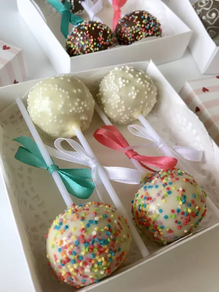 Cake Pops dekorerad med en båge av fläta, förpackade i en presentförpackning. På ytan täckt med dekorativa vit. — Stockfoto